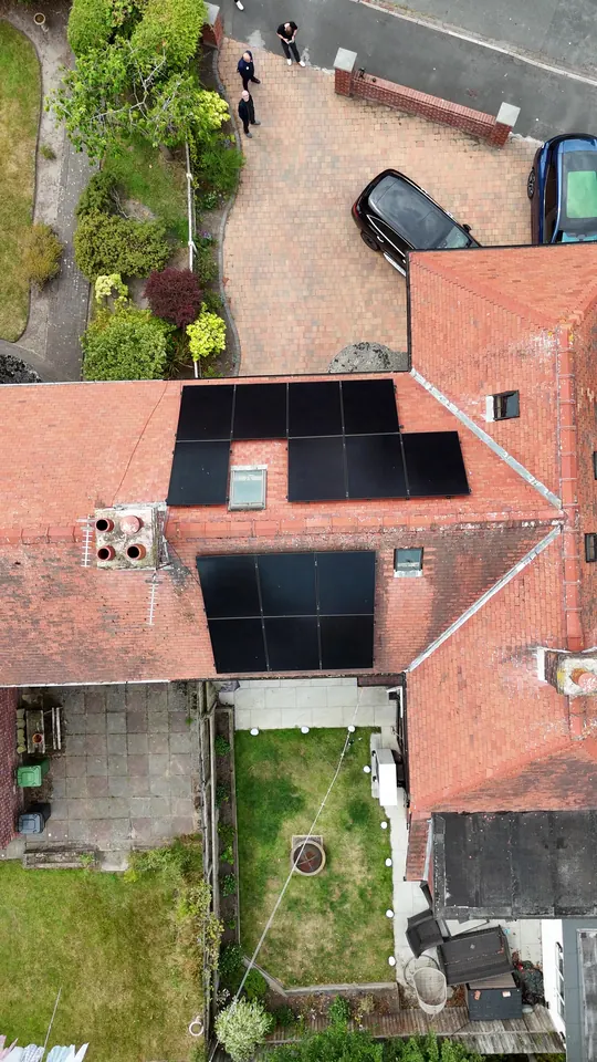 Top-down drone view of the same house showing panels either side of a rooflight on the front slope and a second array on the rear