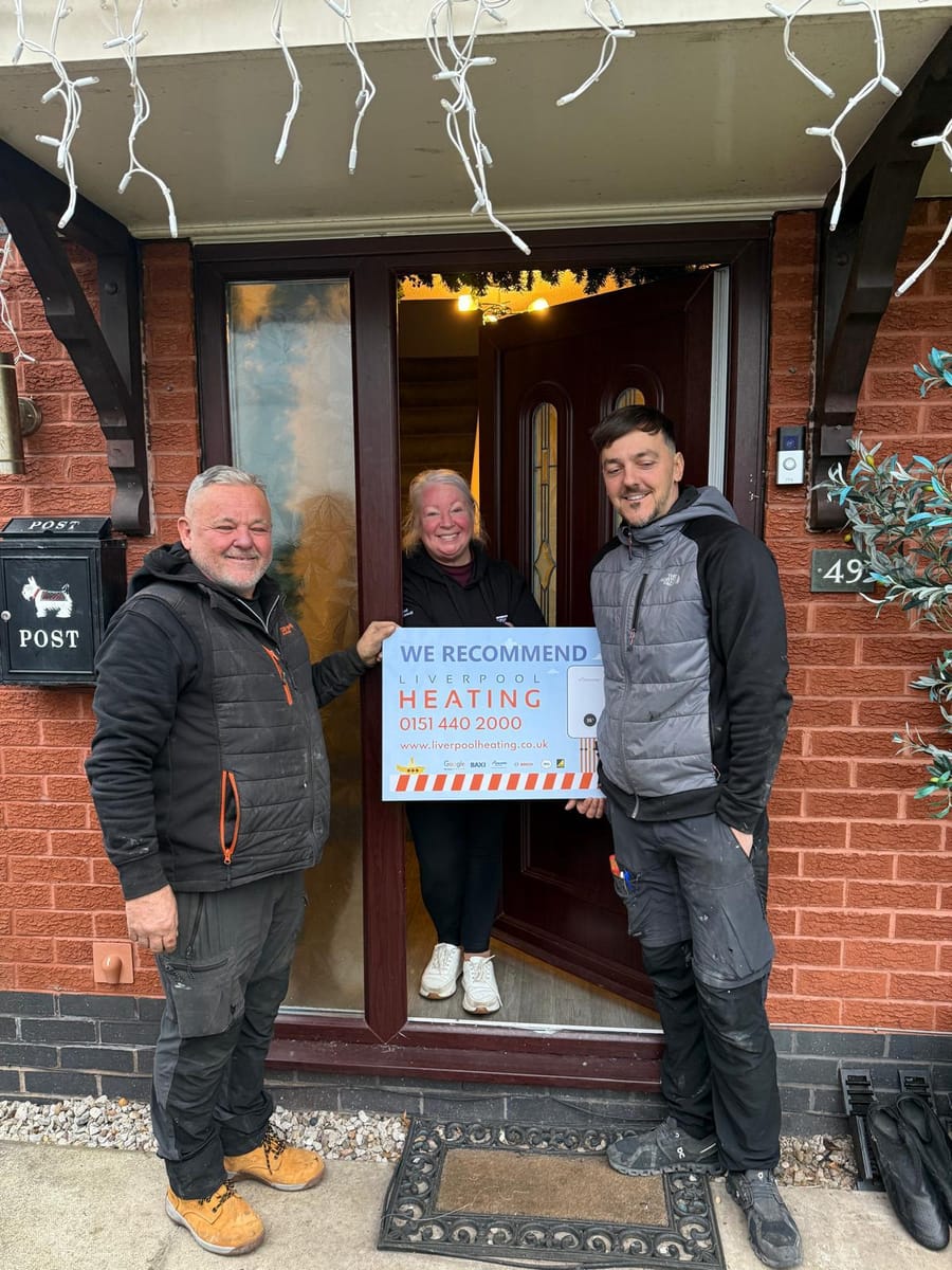 Two Liverpool Heating engineers with a customer at her front door after an installation
